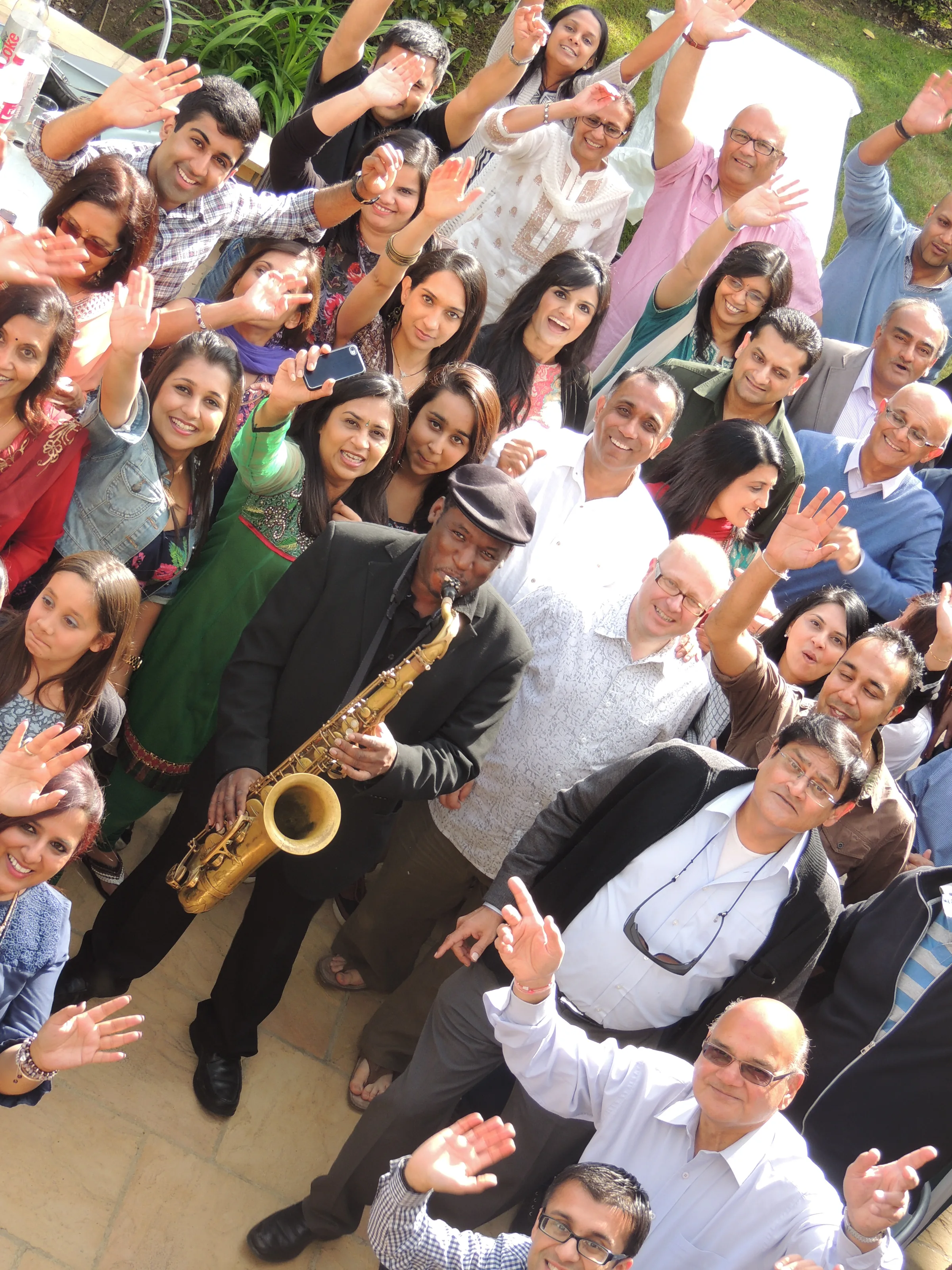 Richie Garrison performing saxophone at a private event — crowd celebrating