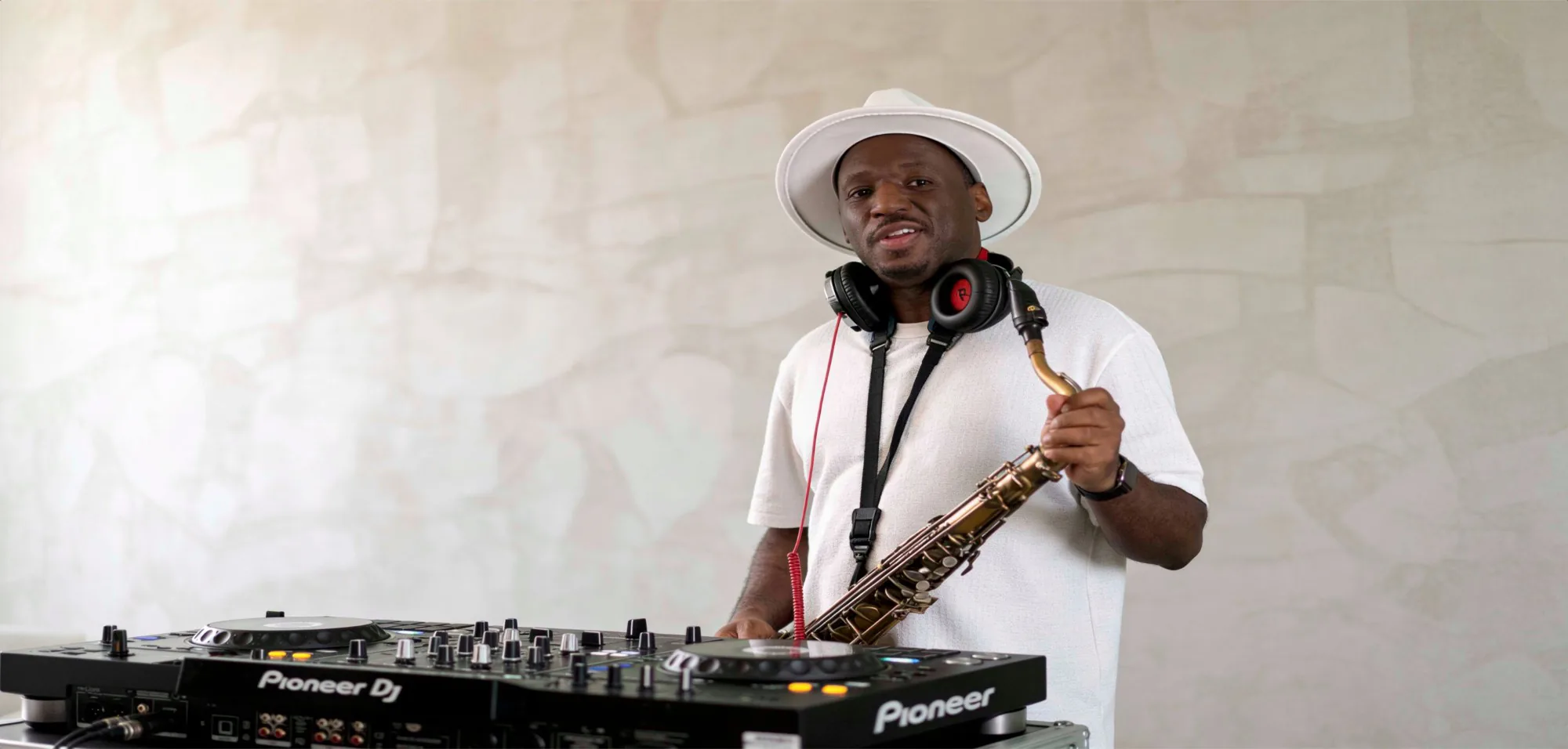 Richie Garrison at Pioneer DJ decks with saxophone