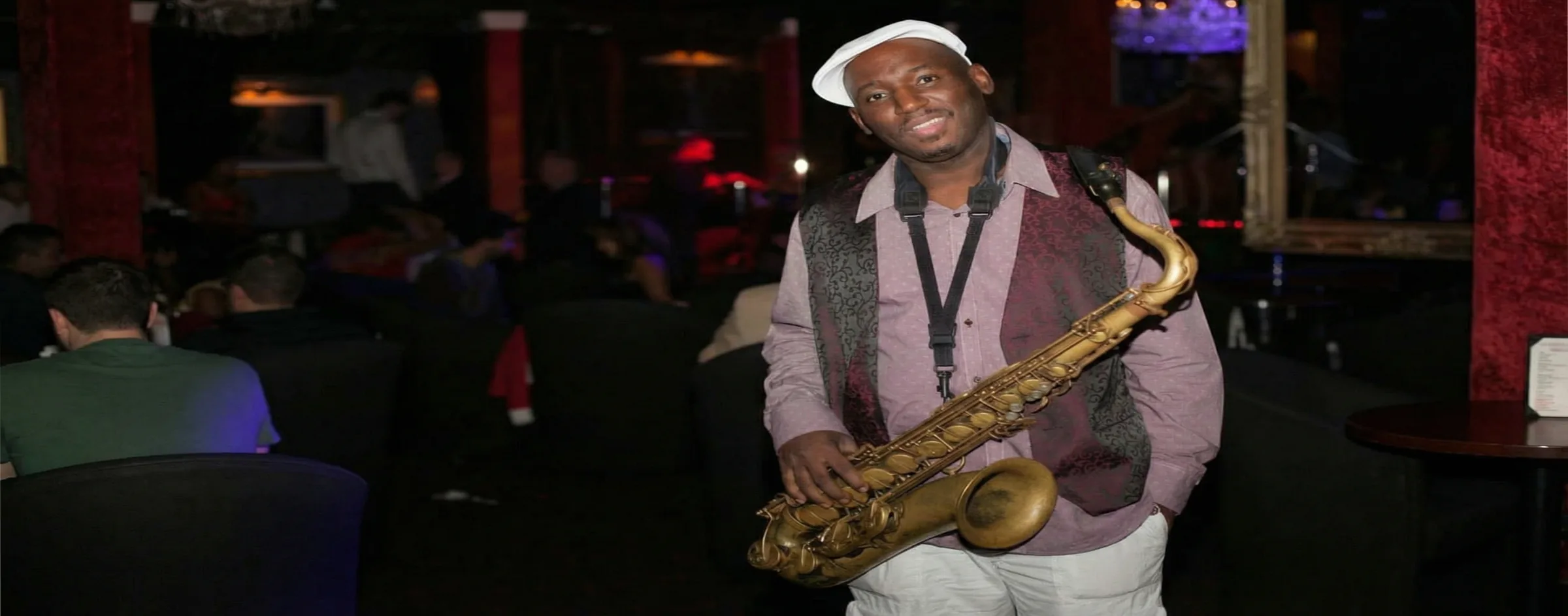 Richie playing saxophone alongside a DJ in a club